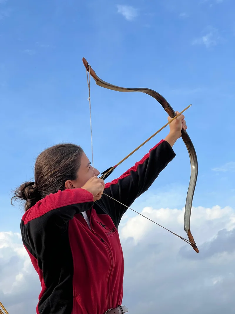 Demet Nebilir beim Bogenschießen im Wald